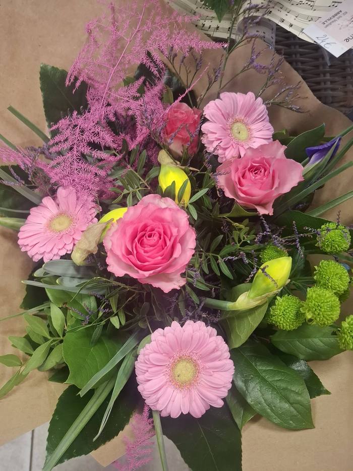 Bouquet aux roses roses et gerberas, emballage partition de musique