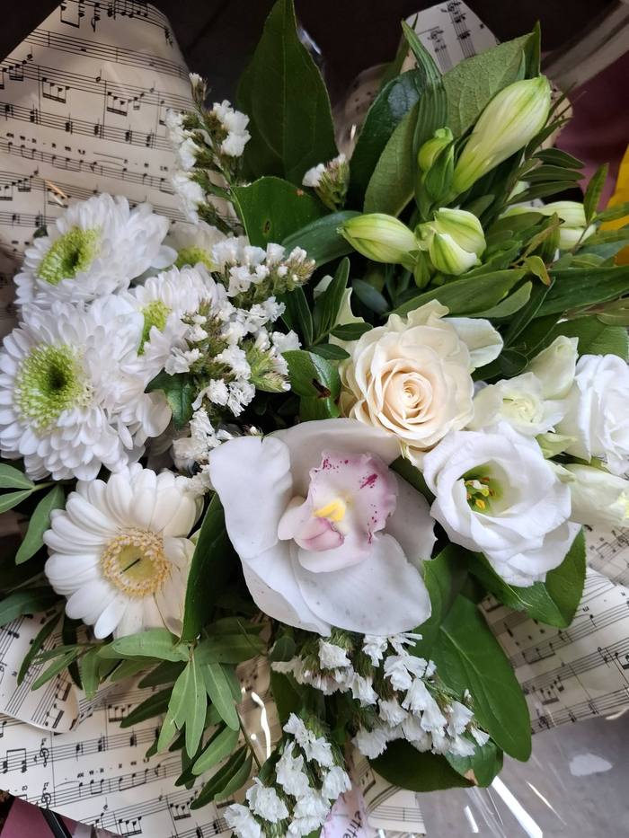 Bouquet de fleurs blanches emballé dans un papier partition de musique