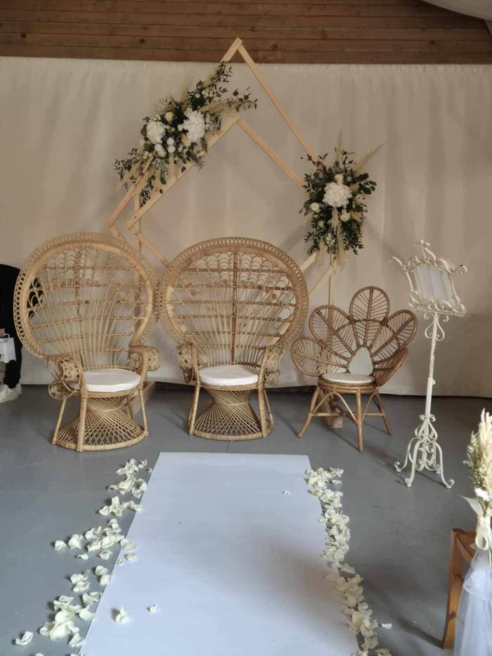 Cérémonie laïque avec fauteuils en rotin et arche florale bohème