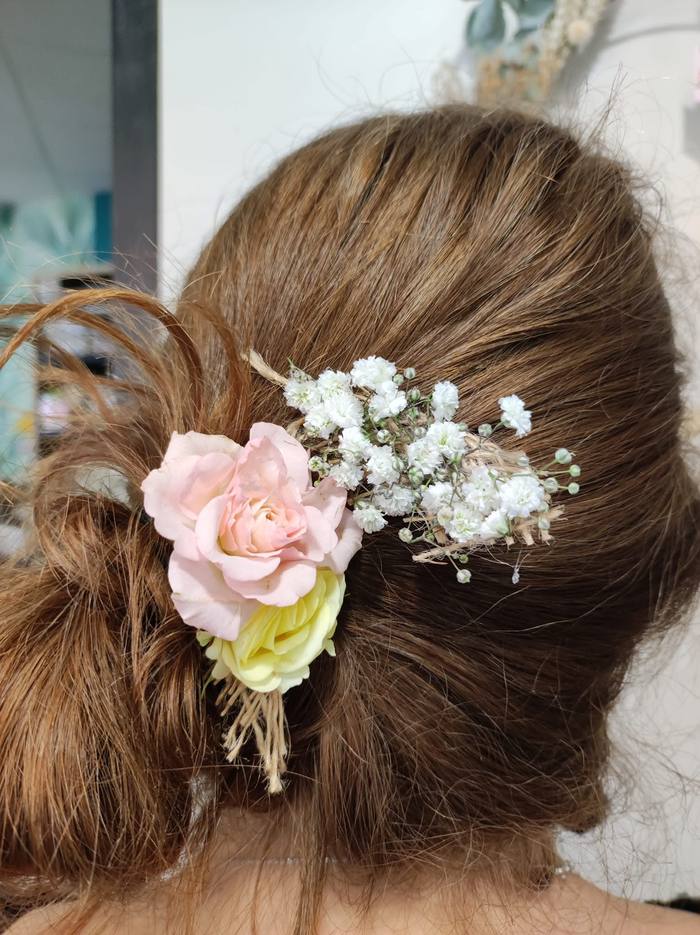 Coiffure de mariée ornée de roses roses et gypsophile