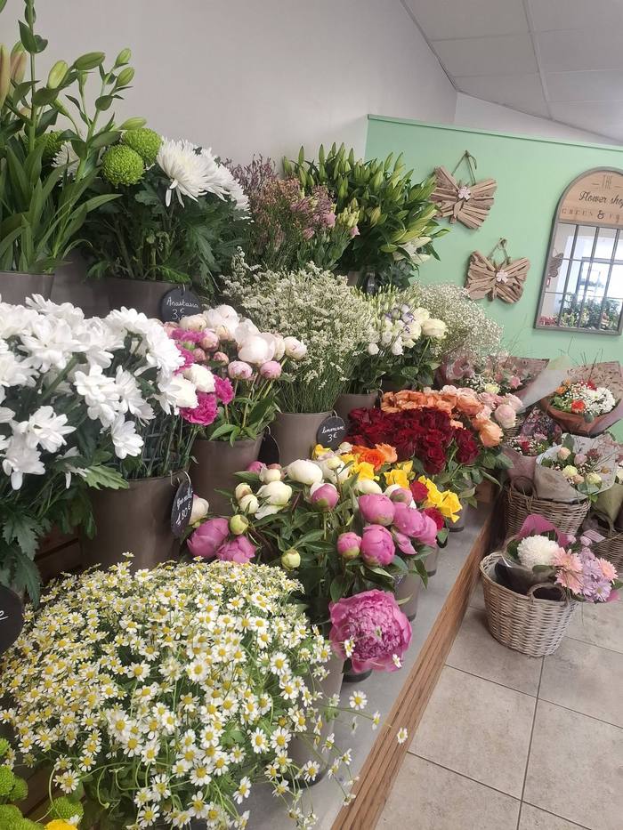Étal de fleurs fraîches en seaux avec prix affichés