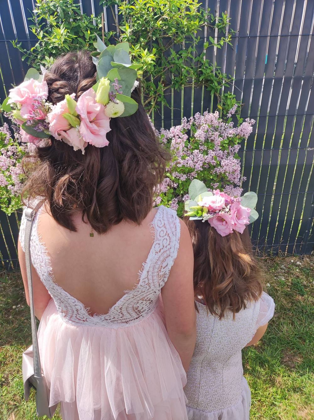 Mère et fille portant des couronnes de fleurs roses pour une cérémonie
