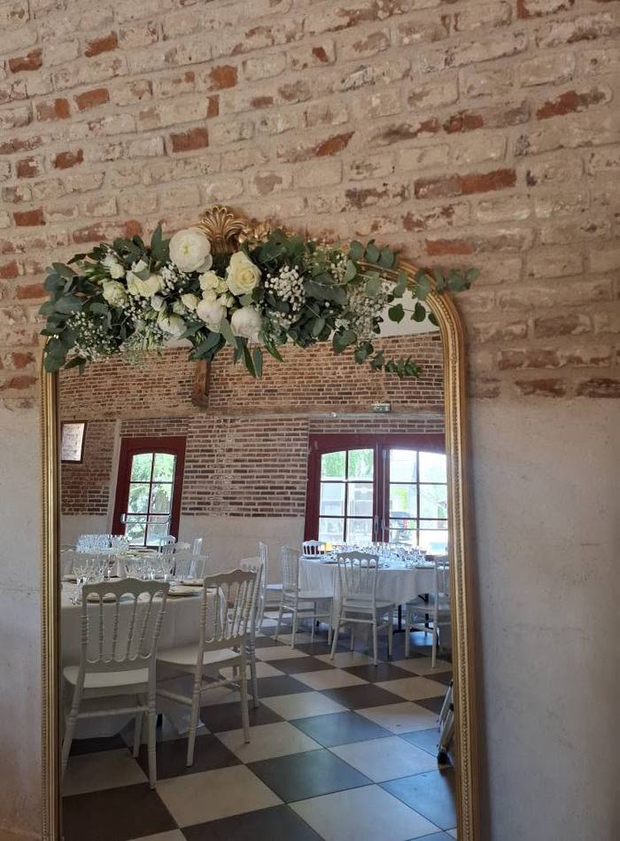 Miroir orné d'une composition florale à l'entrée de la salle