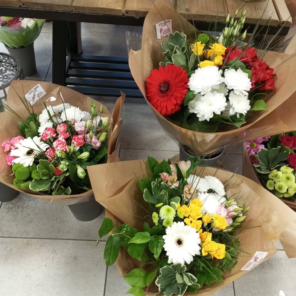 Quatre bouquets variés emballés, prêts à la vente en boutique